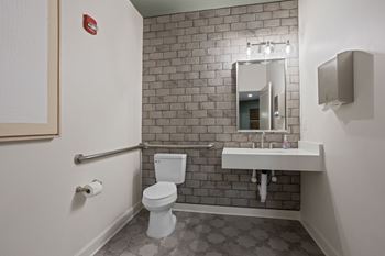 A bathroom with a toilet, sink, and mirror.