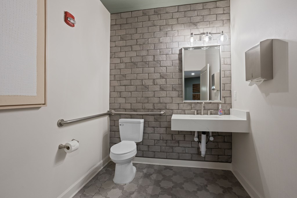 Flatiron West Trade Apartments office bathroom with stone wall