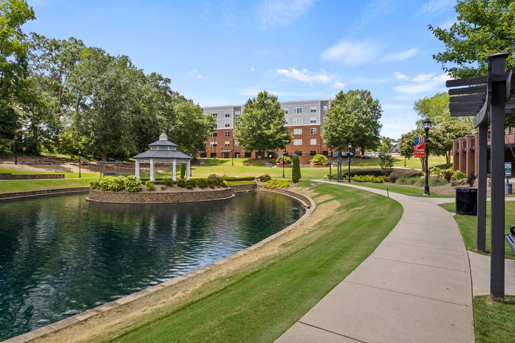 A serene park with a pond, gazebo, and walking path.