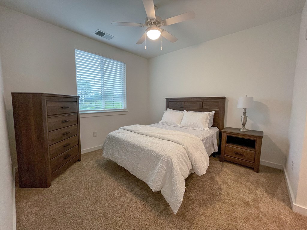 Pet-Friendly Apartments in Greenville, SC - Alston - Bedroom with Full-Size Bed, Nightstand, and Ceiling Fan.