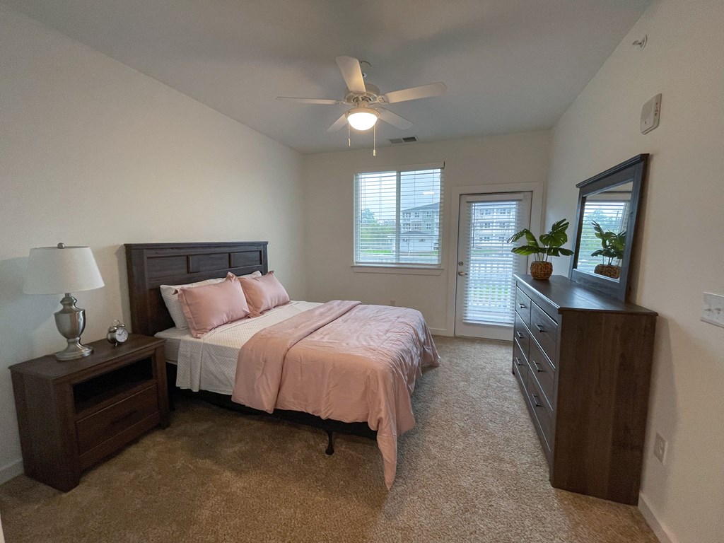 Pet-Friendly Apartments in Greenville, SC - Alston - Bedroom with Full-Size Bed, Nightstand, and Ceiling Fan.