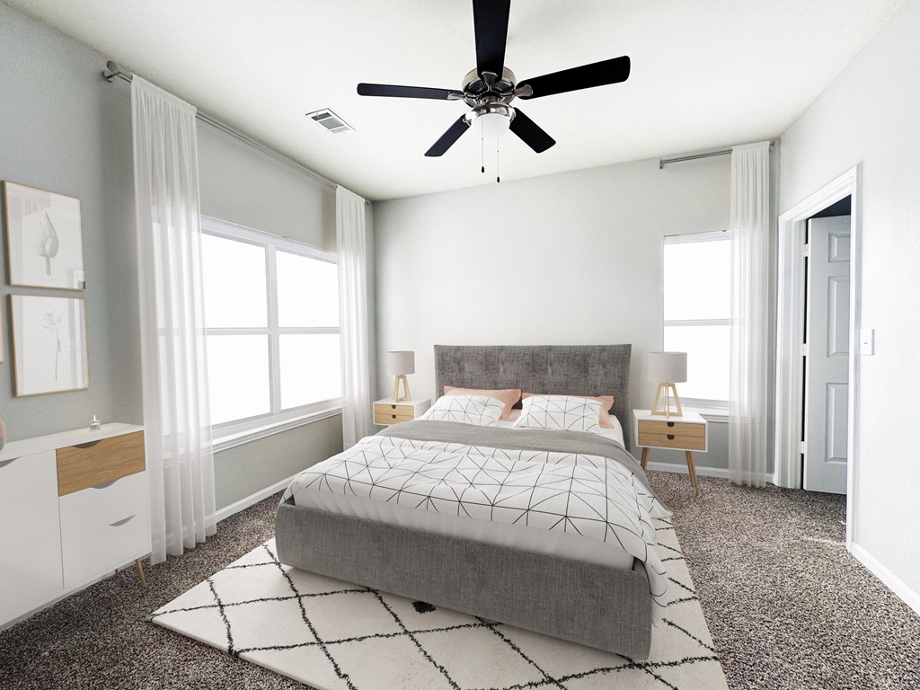A bedroom with a large bed and a ceiling fan.