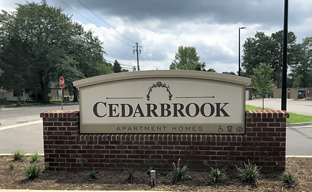 a sign for cedarbrook apartment homes in front of a street