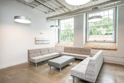 Converse Mill Lofts Luxury Apartments Living Room with Three Couches and an ottoman