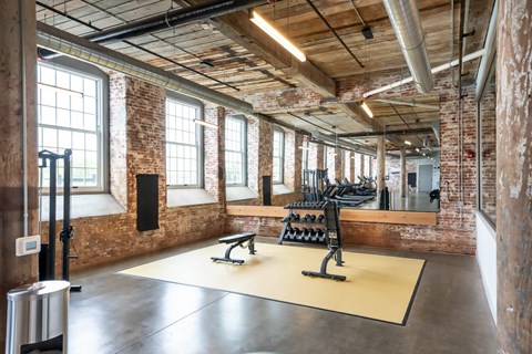Converse Mill Lofts 24/7 Fully Equipped Fitness Center with free weights, two benches and cardio machines