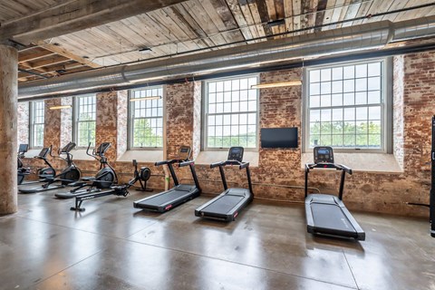 Converse Mill Lofts 24/7 Fully Equipped Fitness Center with three treadmills, two ellipticals and a stationary bike