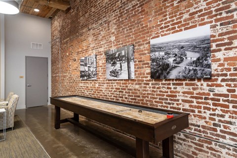 A room with a brick wall and a billiard table.