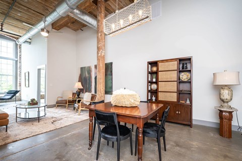 Converse Mill Lofts Luxury Apartments Model Unit Living Room with High Ceilings and Exposed Wood and Brick