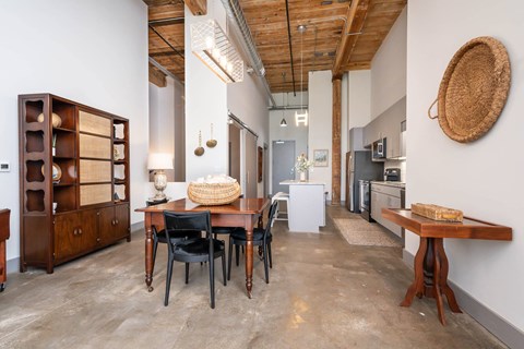 Converse Mill Lofts Luxury Apartments Model Unit Living Room with High Ceilings and Exposed Wood, Brick and Beams