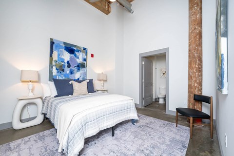 Converse Mill Lofts Luxury Apartments Model Unit Staged Bedroom with high ceilings, exposed beams