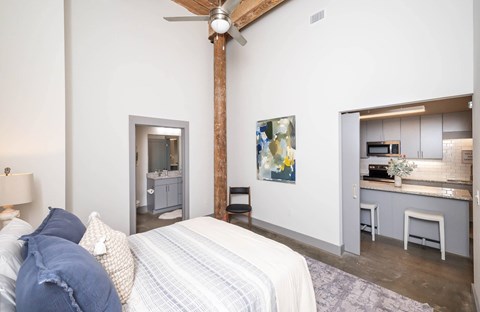 Converse Mill Lofts Luxury Apartments Model Unit Staged Bedroom with high ceilings, exposed beams