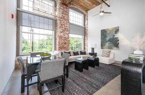 Converse Mill Lofts Luxury Apartments Model Unit Living Room with High Ceilings and Exposed Wood and Brick