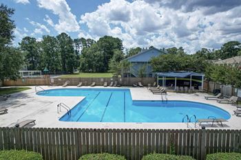 A large blue swimming pool surrounded by a wooden fence.