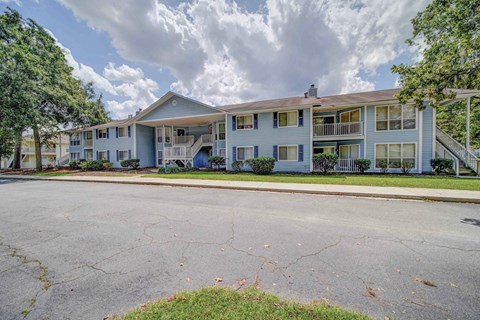 One Bedroom Apartments in Savannah GA - George - Light Blue Property Exterior with Street View, White Trim, and Grassy Lawns
