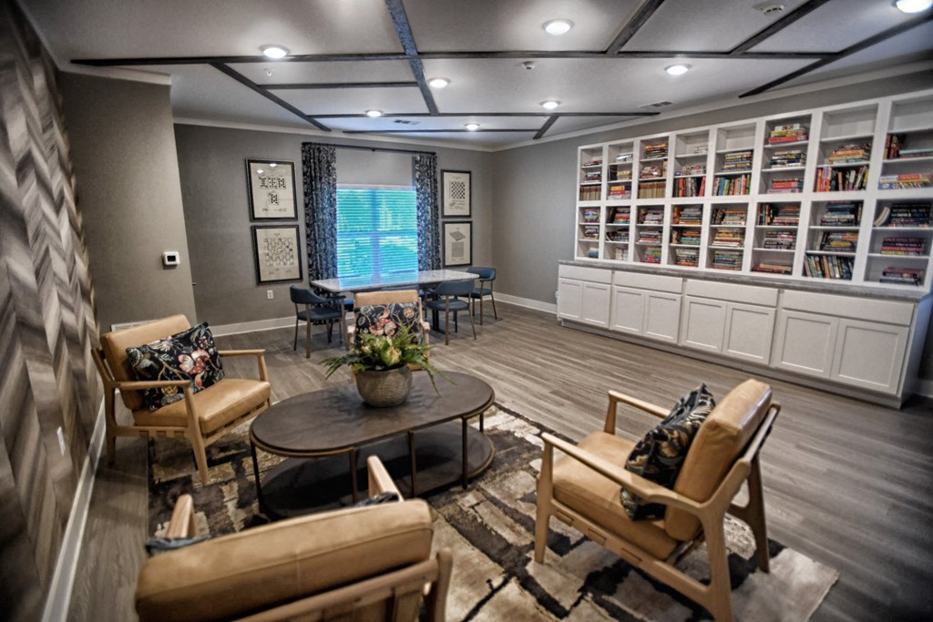 A living room with a sofa, chairs, and a bookshelf.