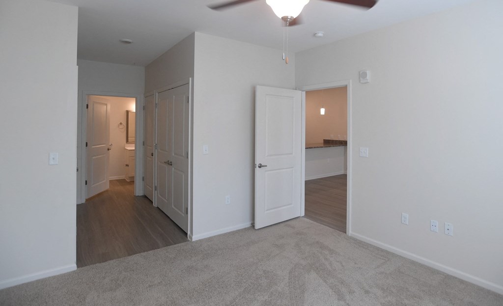 A room with a ceiling fan and carpeted floor.