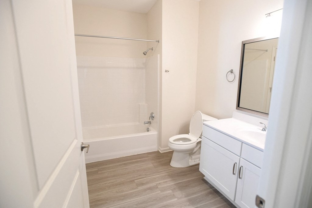 A white bathroom with a toilet, sink, and bathtub.