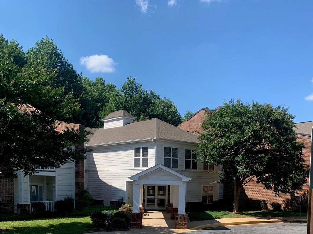 A house with a white front porch and a brown roof.