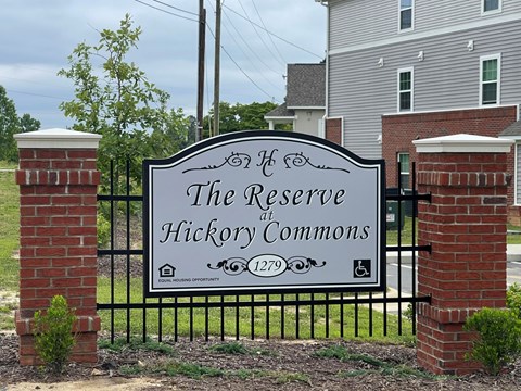 A sign that says "The Reserve at Hickory Commons" is displayed in front of a building.