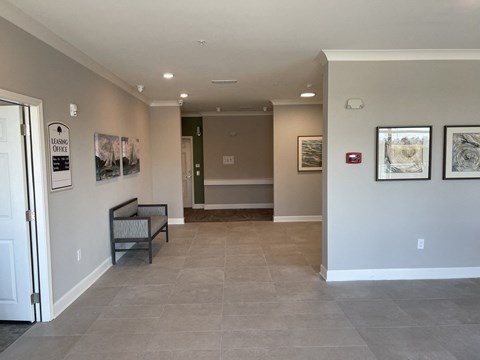 A hallway with a bench and pictures on the wall.
