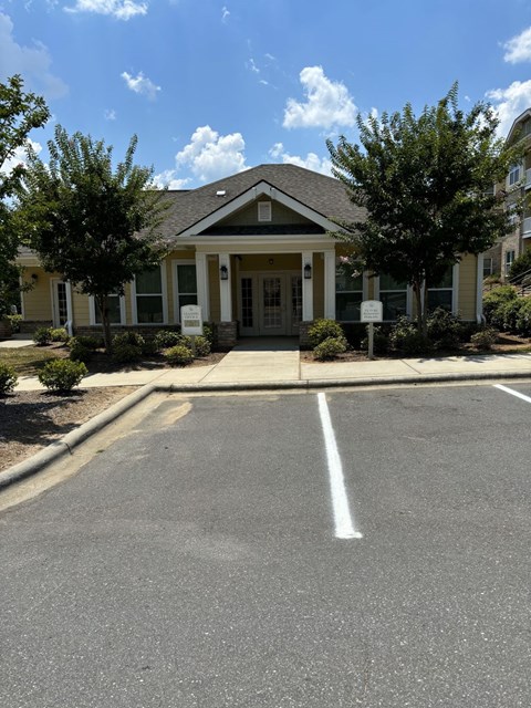 A small building with a parking lot in front.