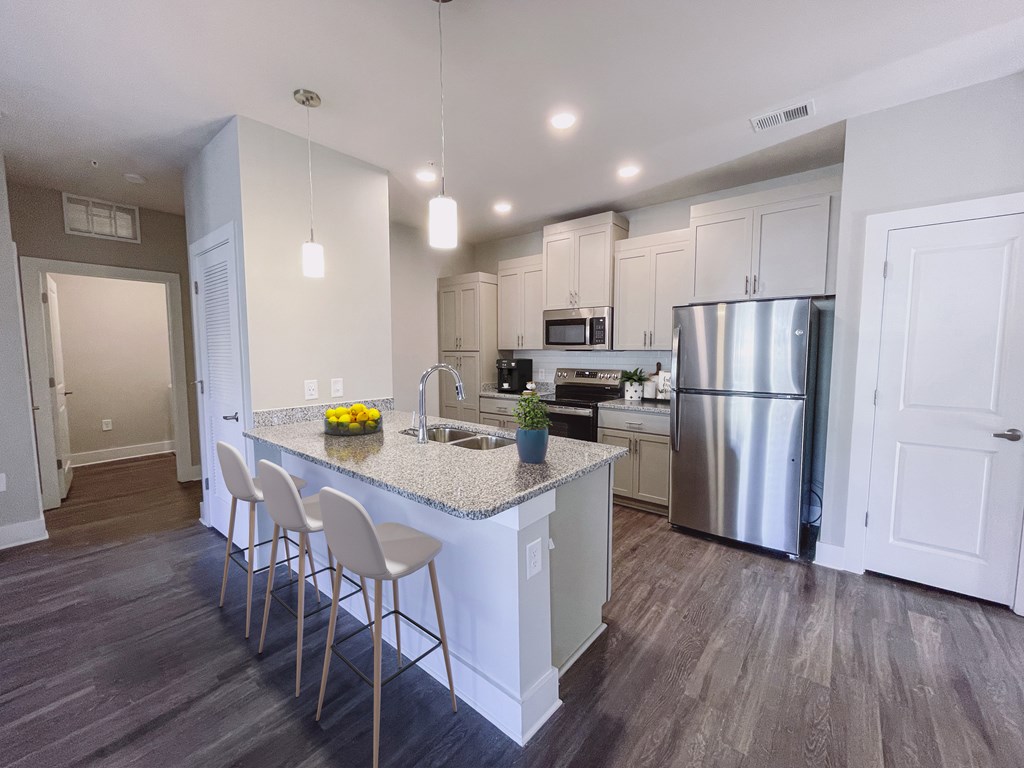 A kitchen with a white island and stainless steel appliances.