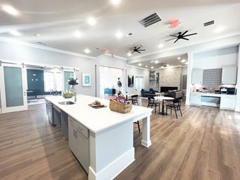 an open kitchen and living room with a large island and a dining room table