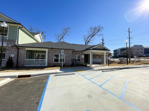 A sunny day at a parking lot with a building in the background.