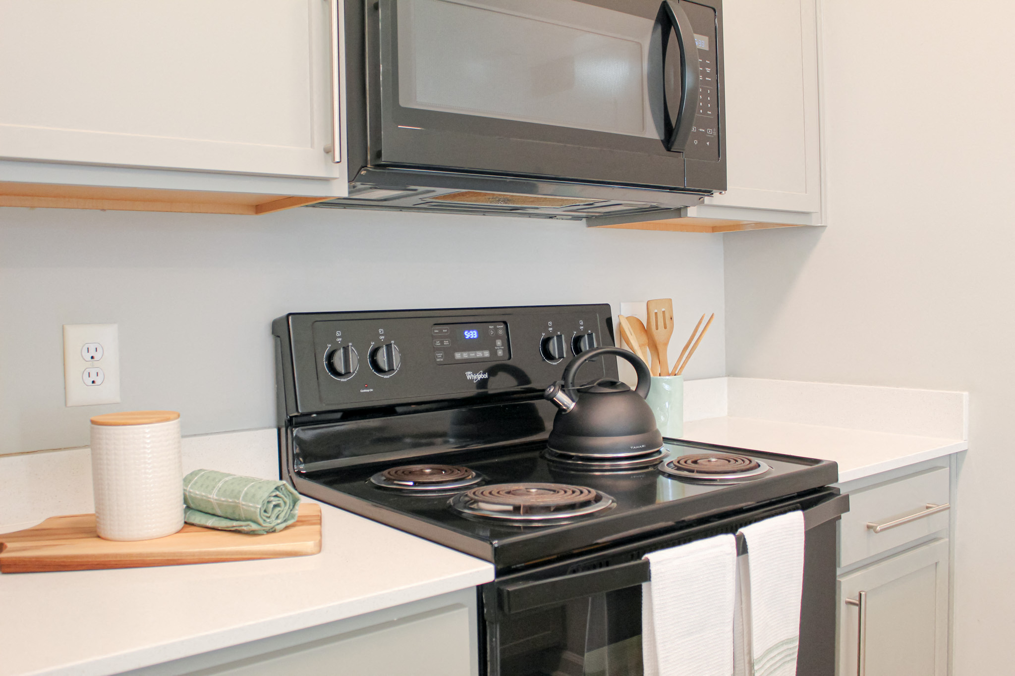 A modern kitchen with a stove top oven and microwave above it.