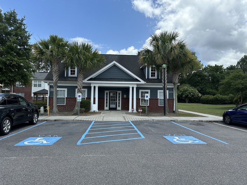 an empty parking lot in front of a building with palm trees