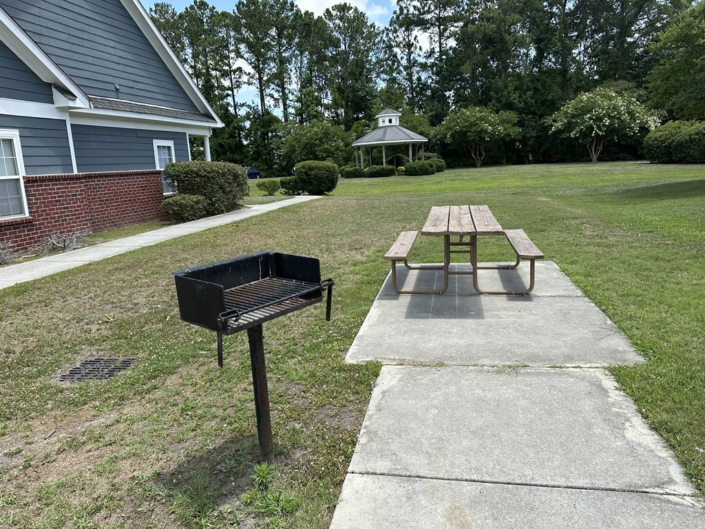 a picnic table and a grill in a yard
