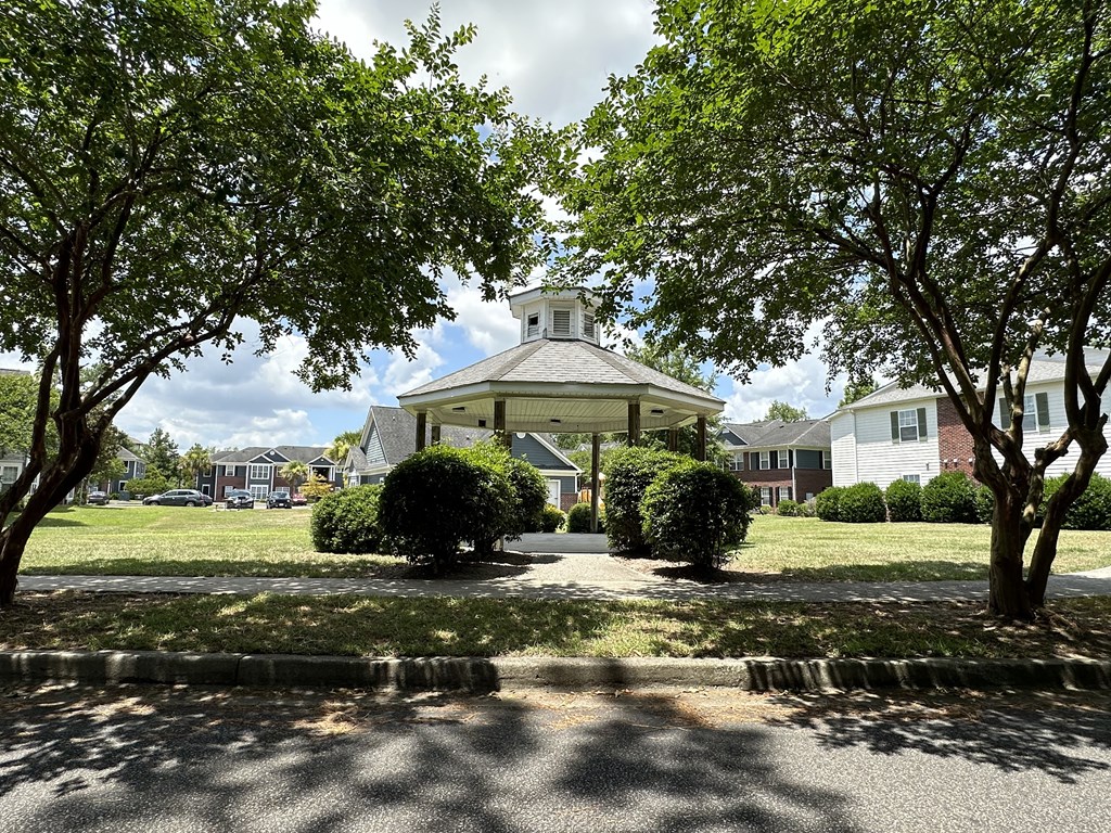 a gazebo in the middle of a park with trees