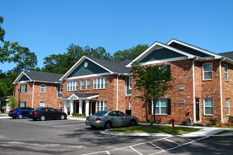 a large brick building with cars parked in a parking lot
