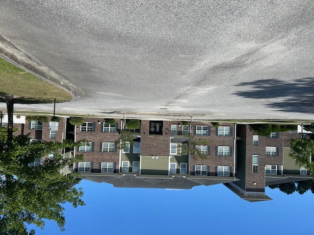 a reflection of an apartment building in a pool of water
