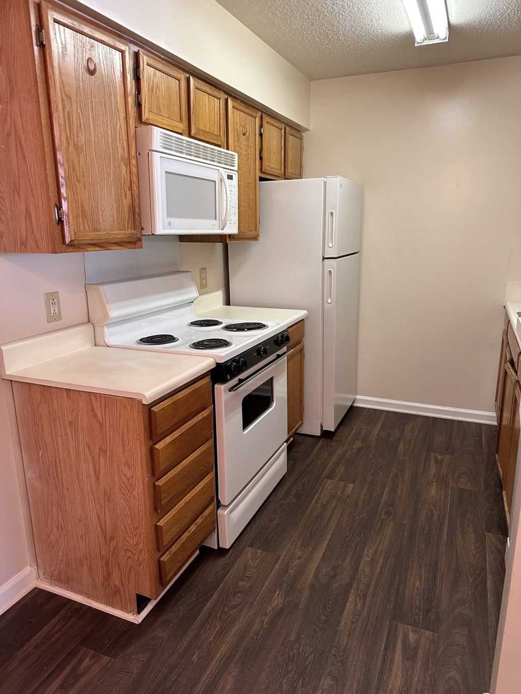 A kitchen with wooden cabinets and white appliances.
