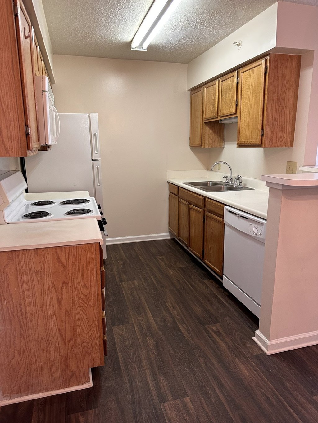 A kitchen with a white stove and wooden cabinets.