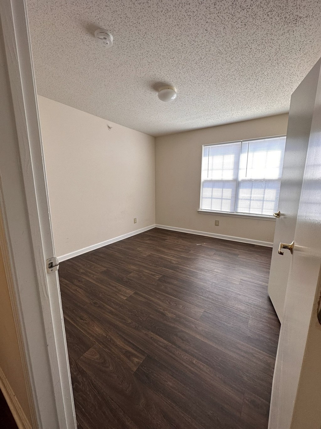 A room with wooden floors and a window.