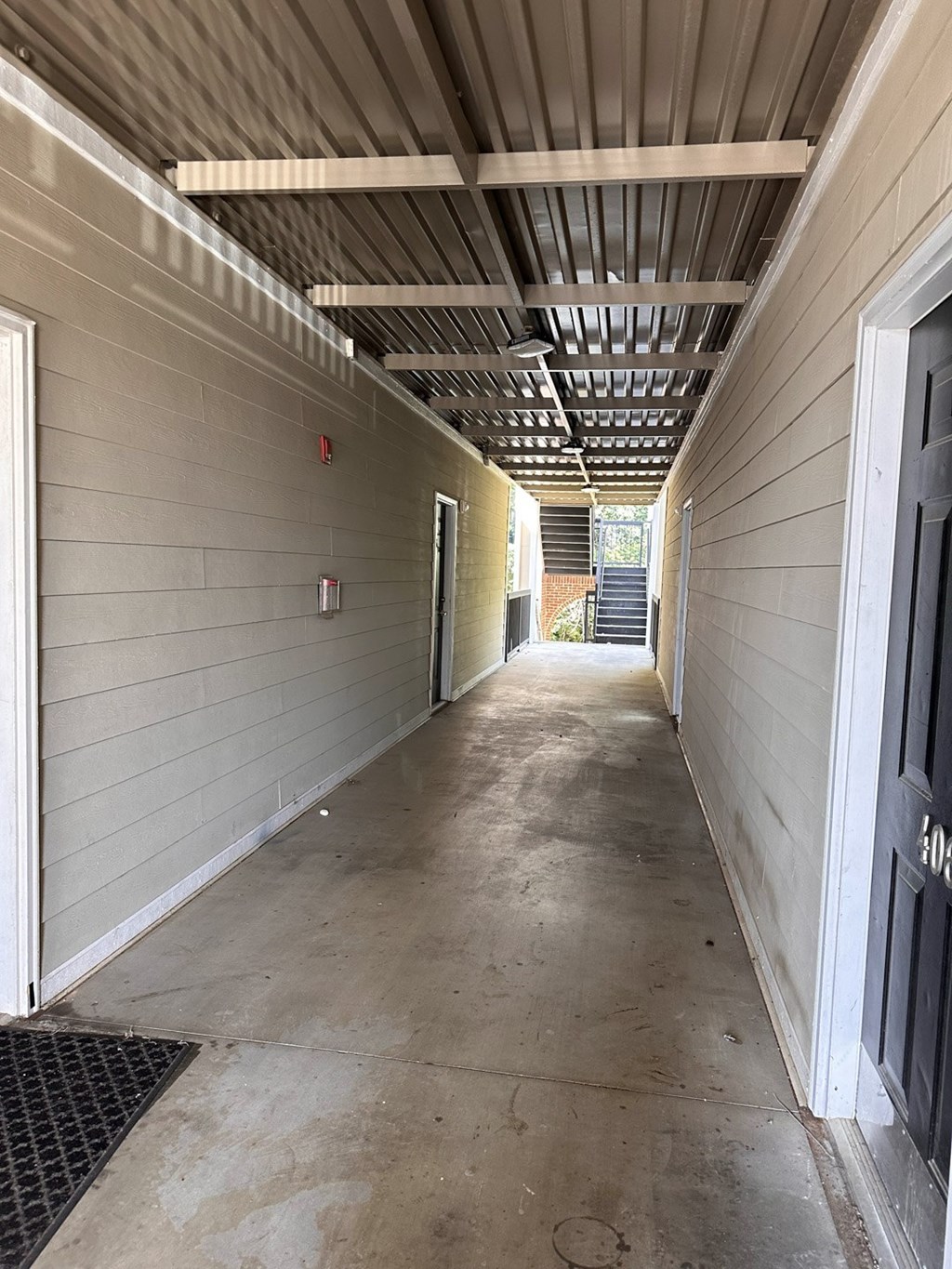 A long, narrow hallway with a metal grate on the floor.