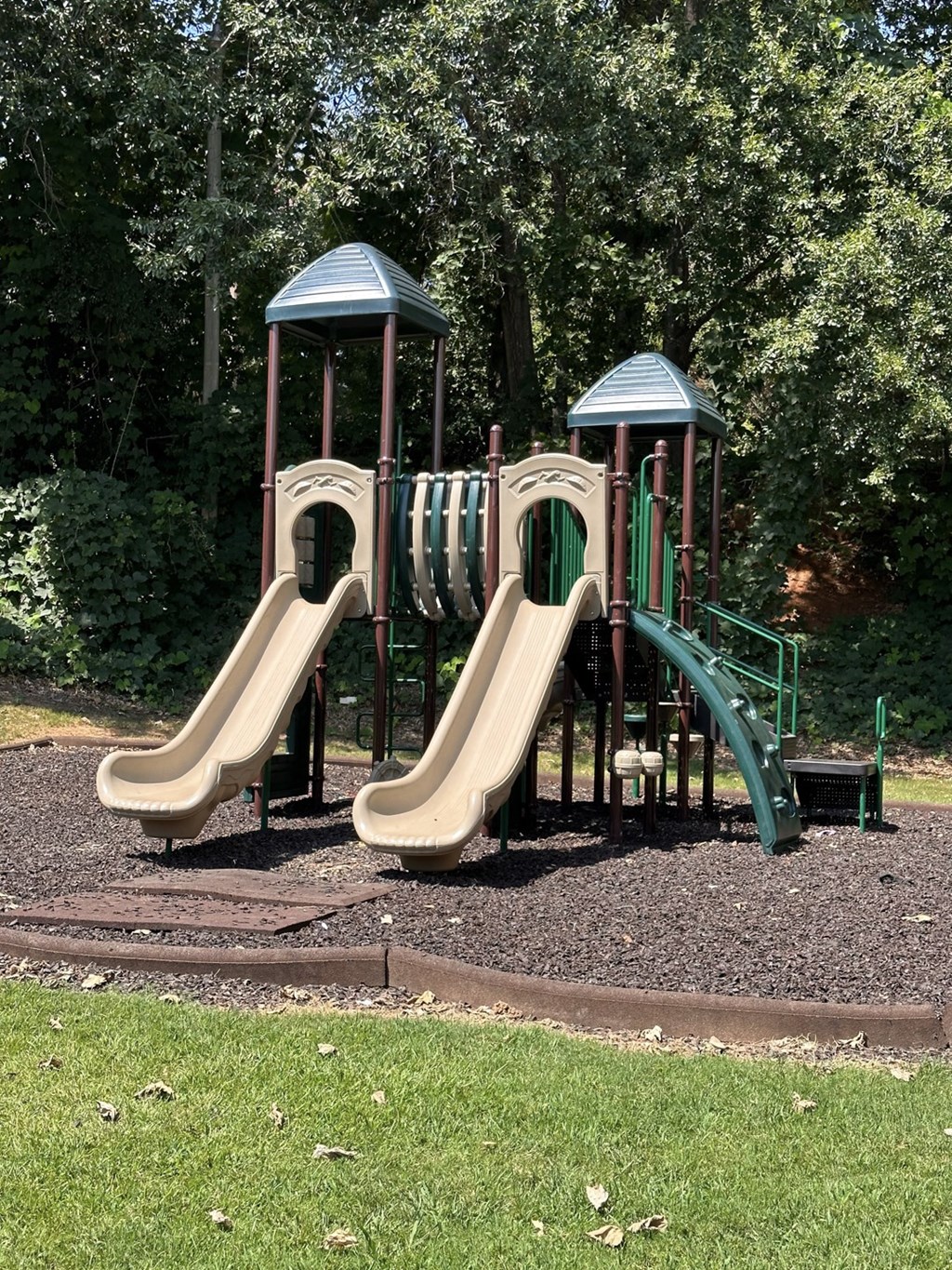 A playground with two slides and two towers.