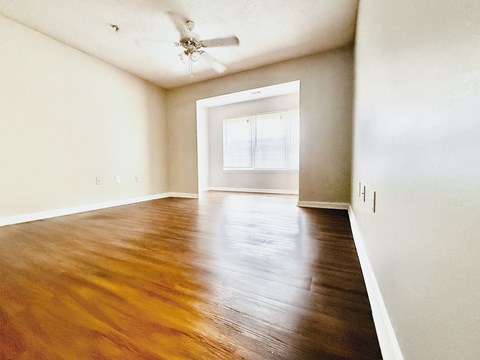 A room with wooden flooring and a ceiling fan.