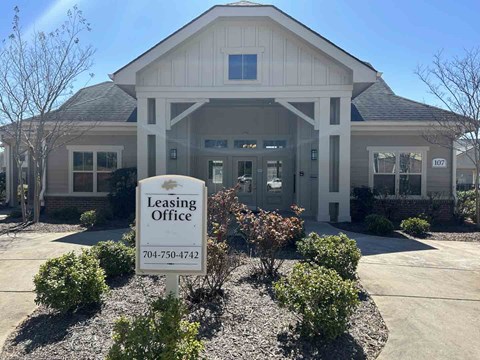 A leasing office building with a sign in front.