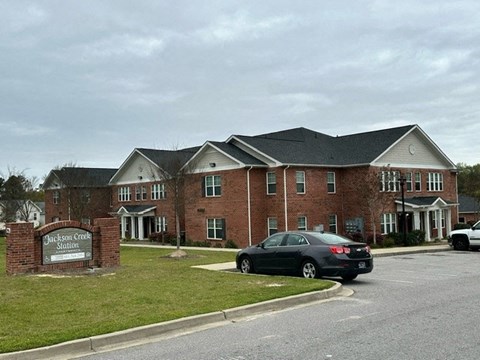 a car parked in front of a large brick house