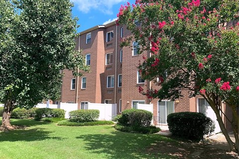 A red brick building with a green lawn in front.
