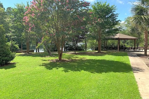 A gazebo sits in the middle of a grassy area.