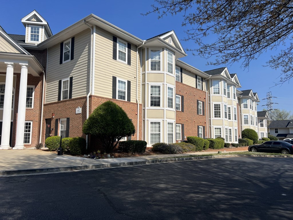 A row of townhouses with a car parked in front.