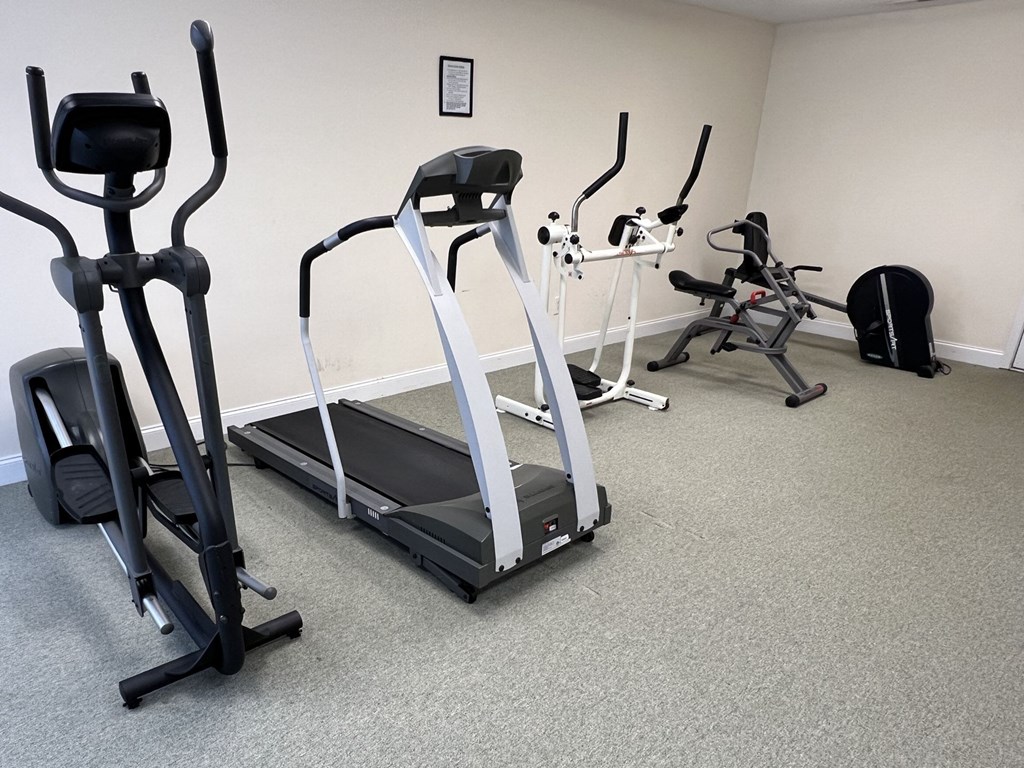 A room with a treadmill, elliptical trainer, and a stationary bike.