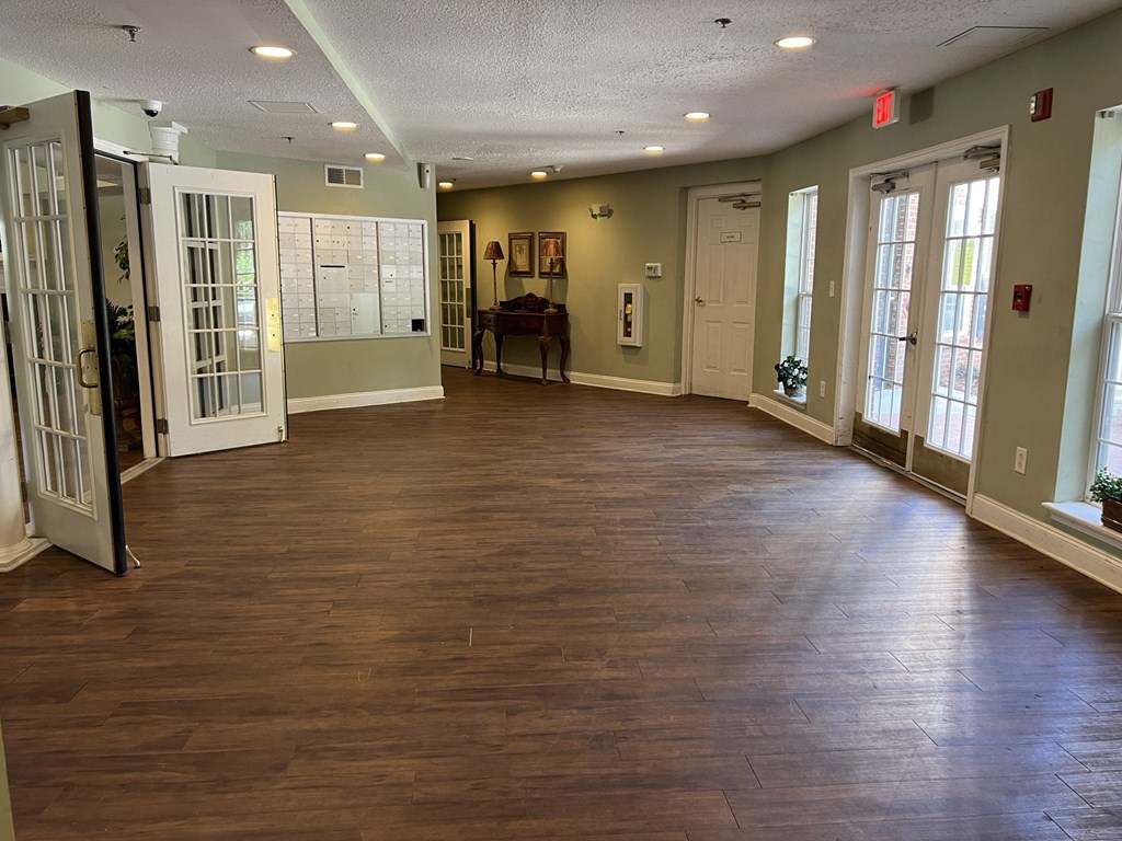 A room with wooden floors and a piano in the corner.