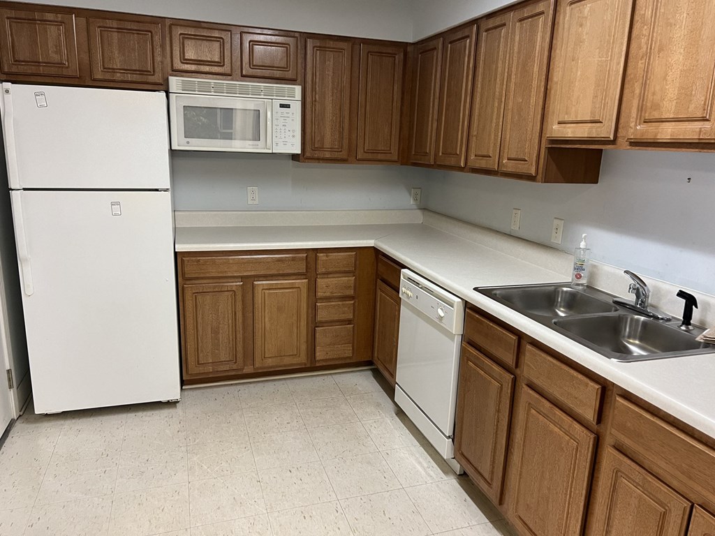 A kitchen with wooden cabinets and white appliances.
