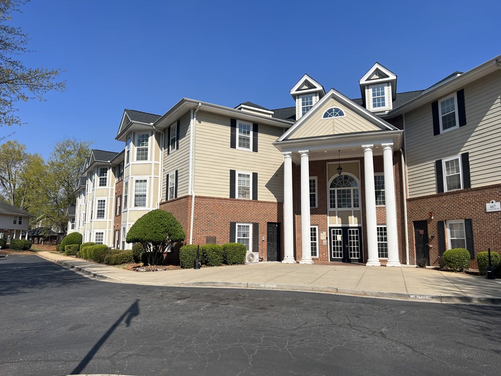 A large apartment building with a front entrance and pillars.