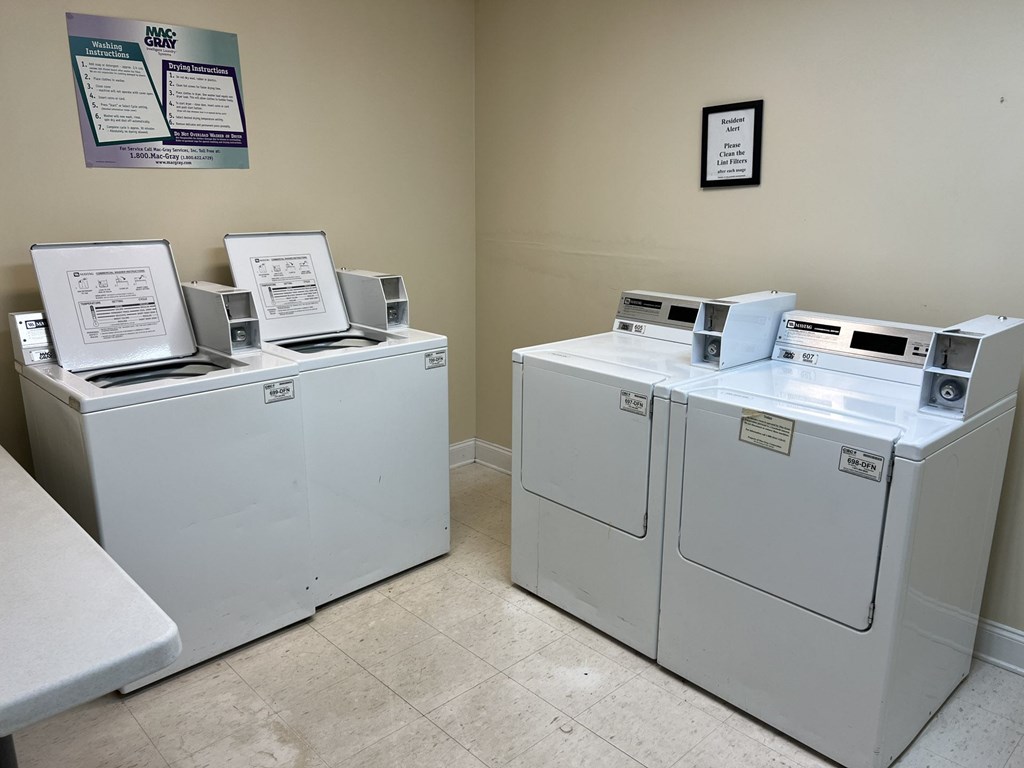 A room with a row of washing machines.